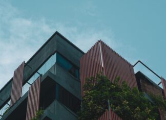 Jaką rolę w rozwoju budownictwa energooszczędnego odegrał Norman Foster i jego biuro Nowoczesny tropikalny budynek z pionowymi lamelami i roślinnością