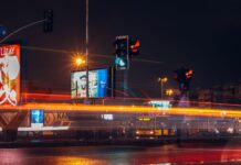 Nocna ulica w mieście z ruchem aut i smugami świateł