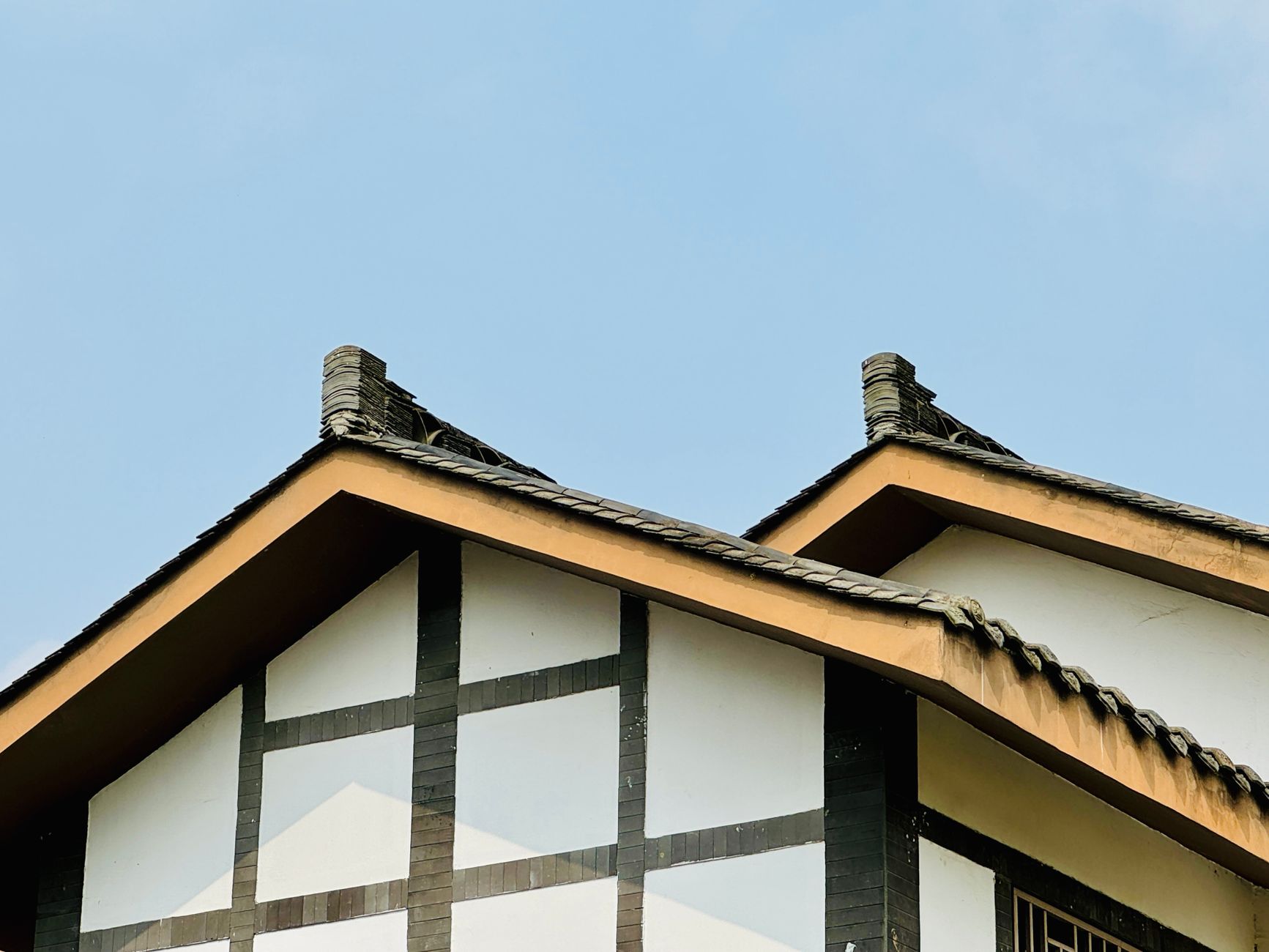 Tradycyjny drewniany dach z detalami architektonicznymi na tle błękitnego nieba